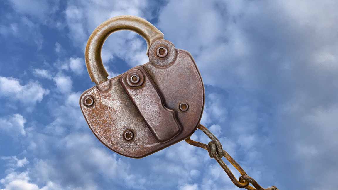 A rusty old, but functional-appearing lock over a sky full of clouds