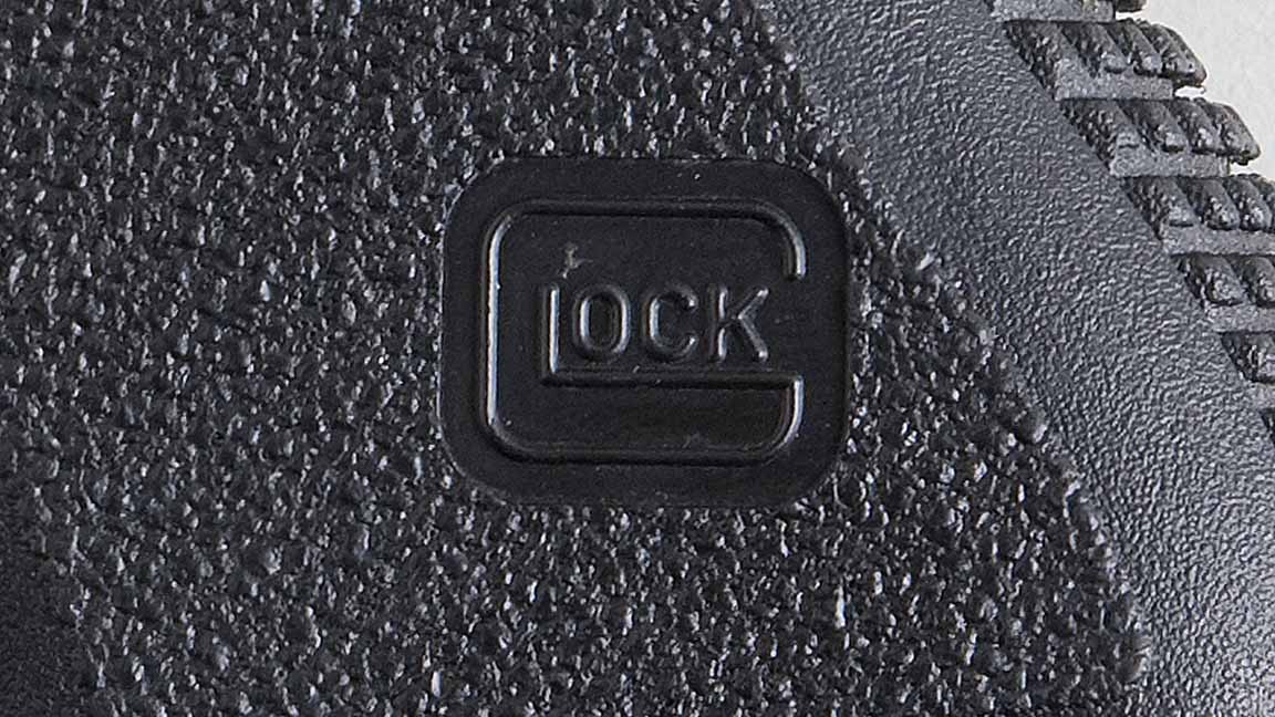 An extreme closeup of the GLOCK logo on a Glock 26 hand gun