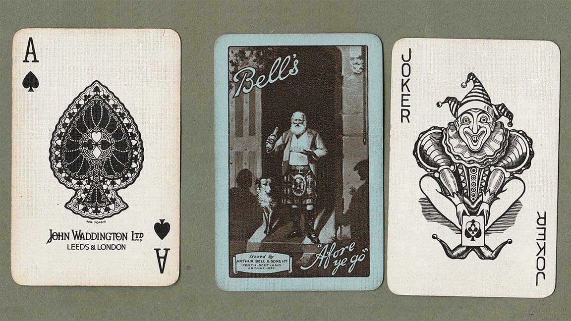 Three old playing cards, from right to left: an ace of spades, reading JOHN WADDINGTON LTD., LEEDS & LONDON, a back side reading BELL'S "Afore ye go," Issued by ARTHUR BELL & SONS LTD, PERTH SCOTLAND, with an image of a bearded older man in a llt staning in a castle doorway, holding a bottle, with a dog at his side, flanked by the shadows to two people, and the third card is a JOKER