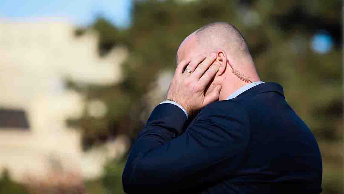 Shallow depth of field (selective focus) image with the coiled tube earpiece a Protection and Guard Service (SPP, Romanian version of the US Secret Service) officer is wearing during a public visit of a dignitary.