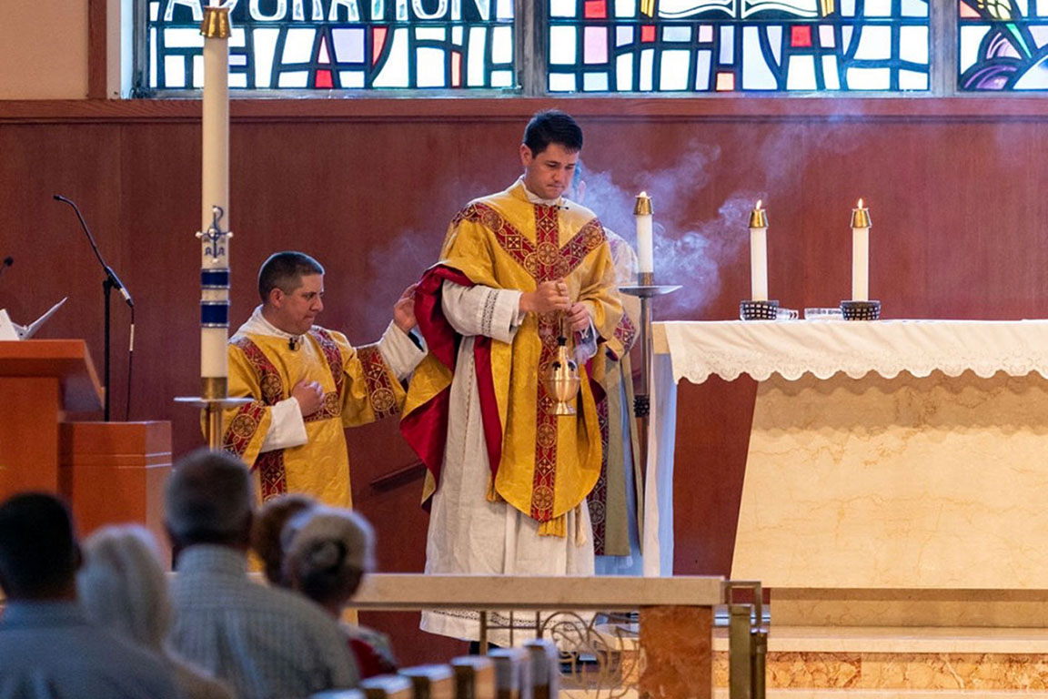 A priest and assistans serving mass in a church